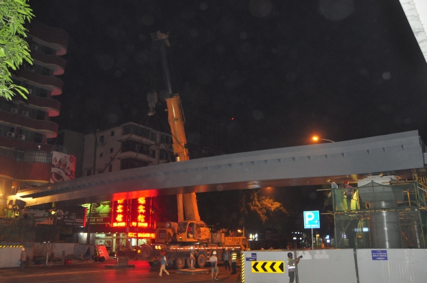 长38米、重达87吨的钢箱梁，，，，，，，被200吨吊车稳稳地吊装在两个桥梁墩柱之上